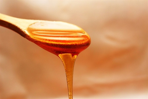 Honey dripping from honey dipper