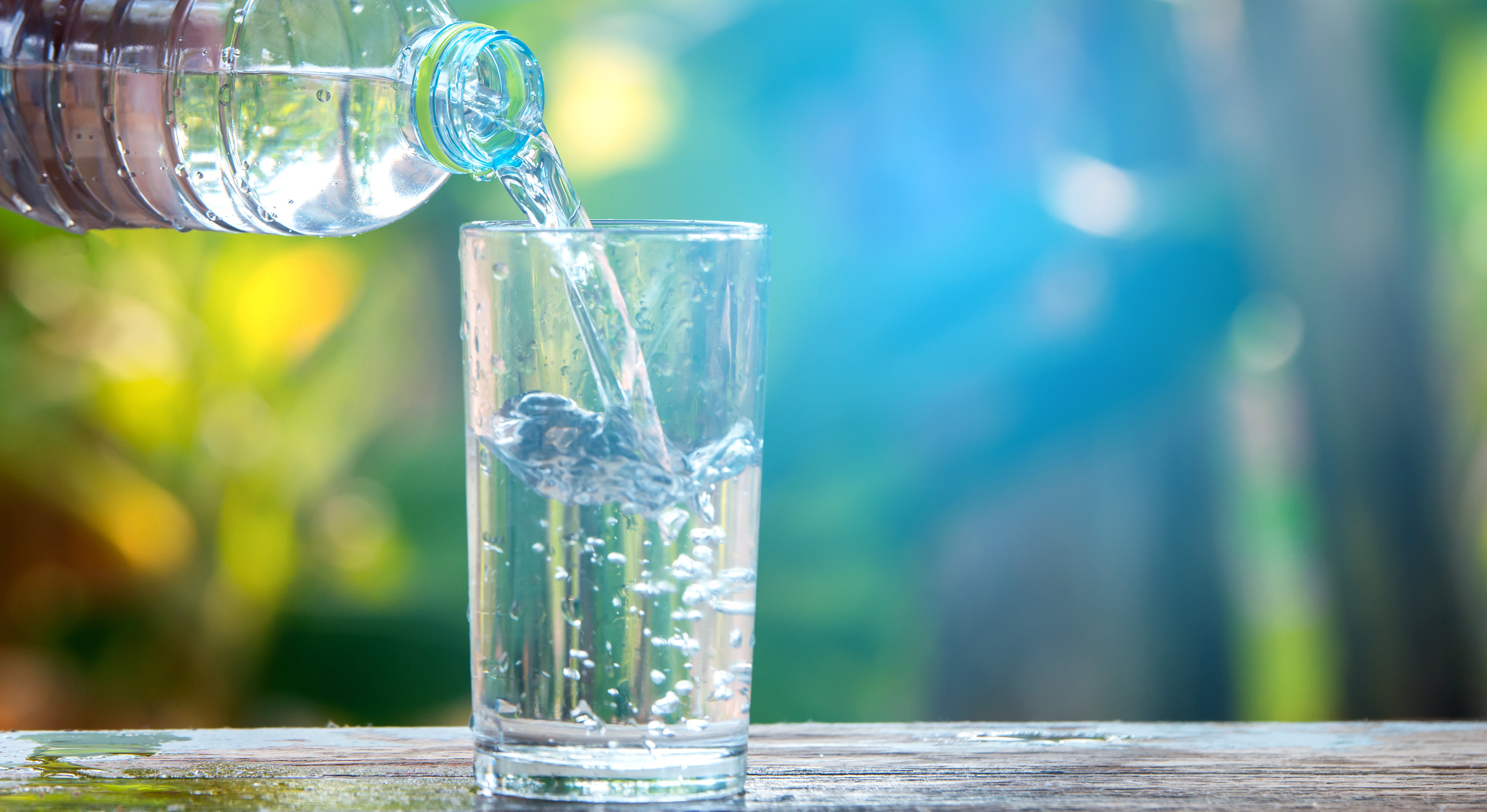 Drikkevann helles over i glass fra flaske