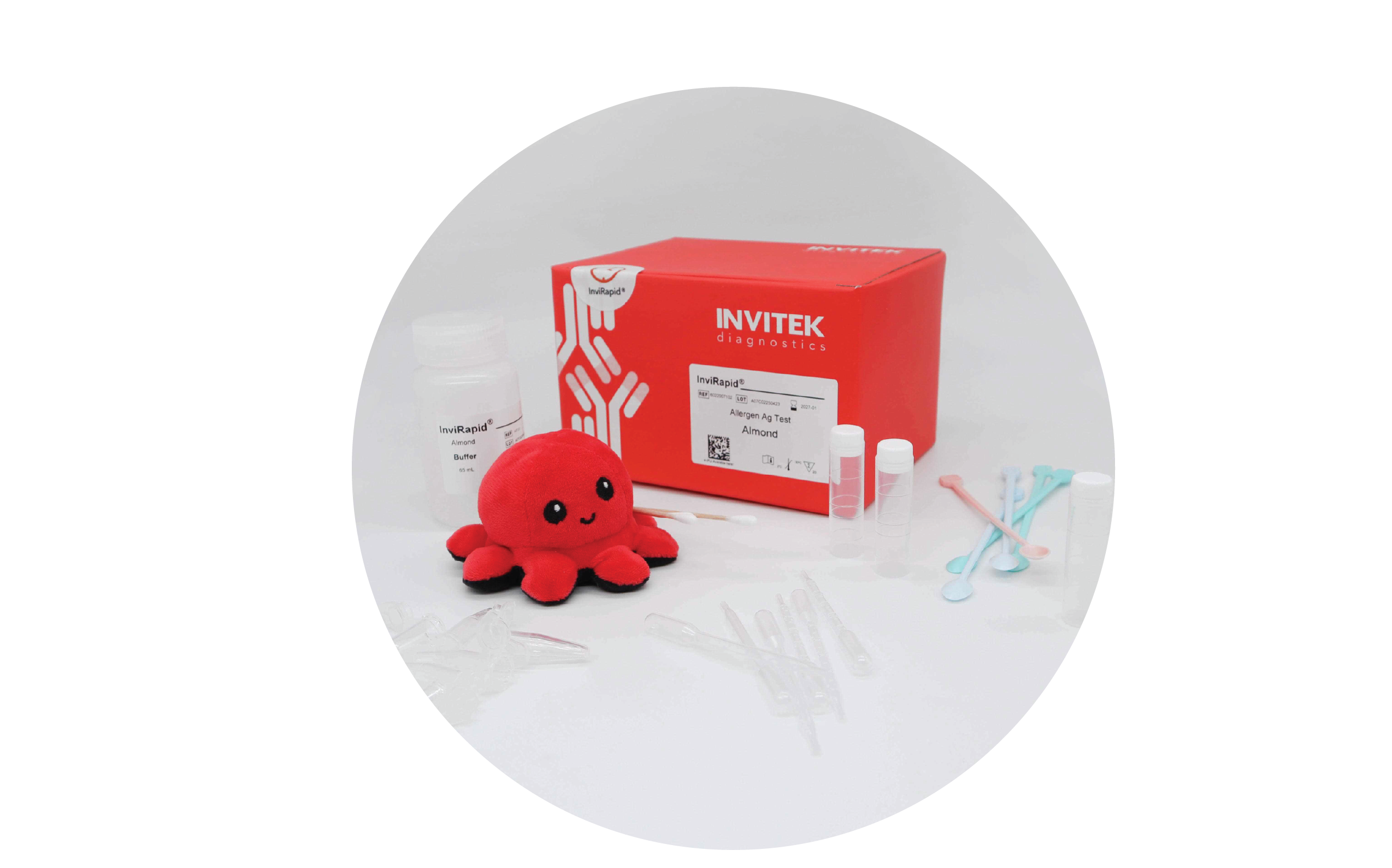 Red Invitek Diagnostics InviRapid Almond Allergen Ag Test box behind a buffer bottle and sample tubes with scoops, droppers, swabs, and tubes laying scattered in front.
