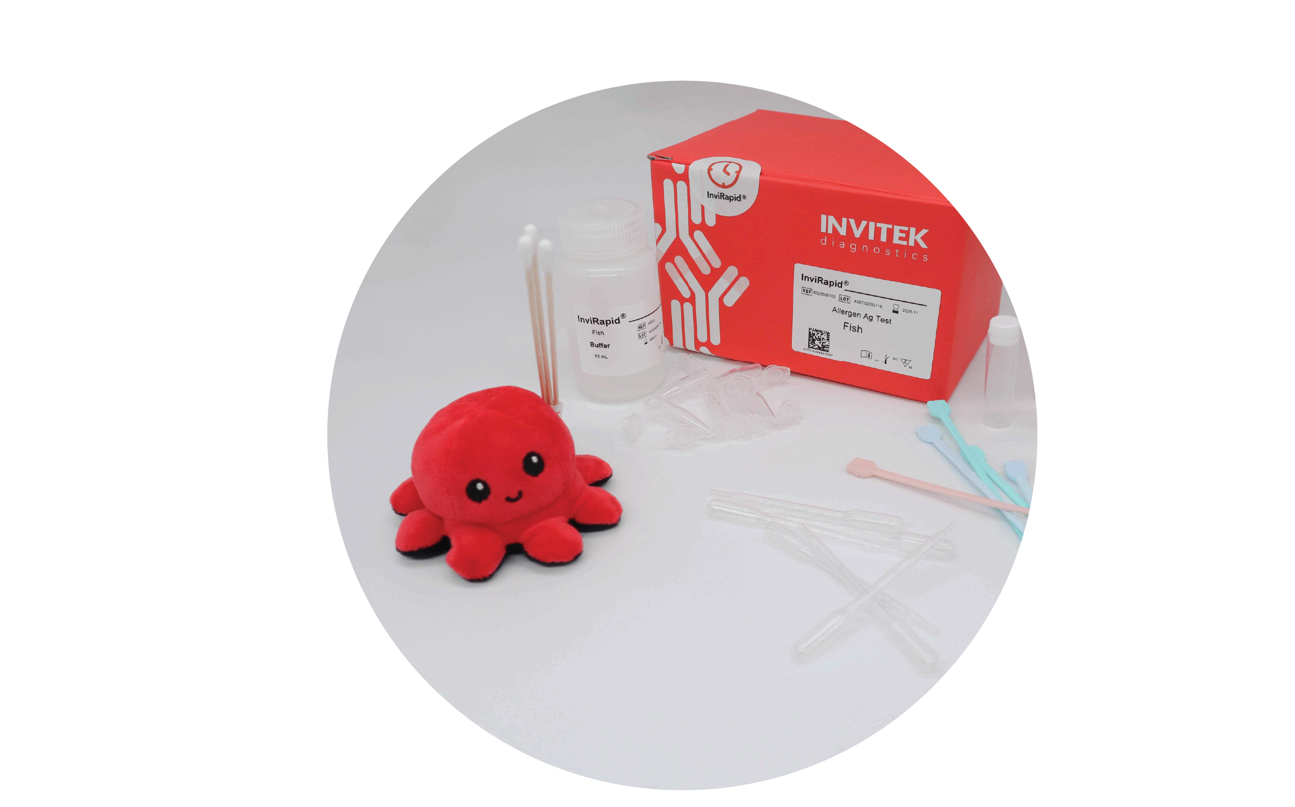 Red Invitek Diagnostics InviRapid Fish Allergen Ag Test box behind a buffer bottle and sample tubes next to swabs with scoops, droppers and tubes laying scattered in front.