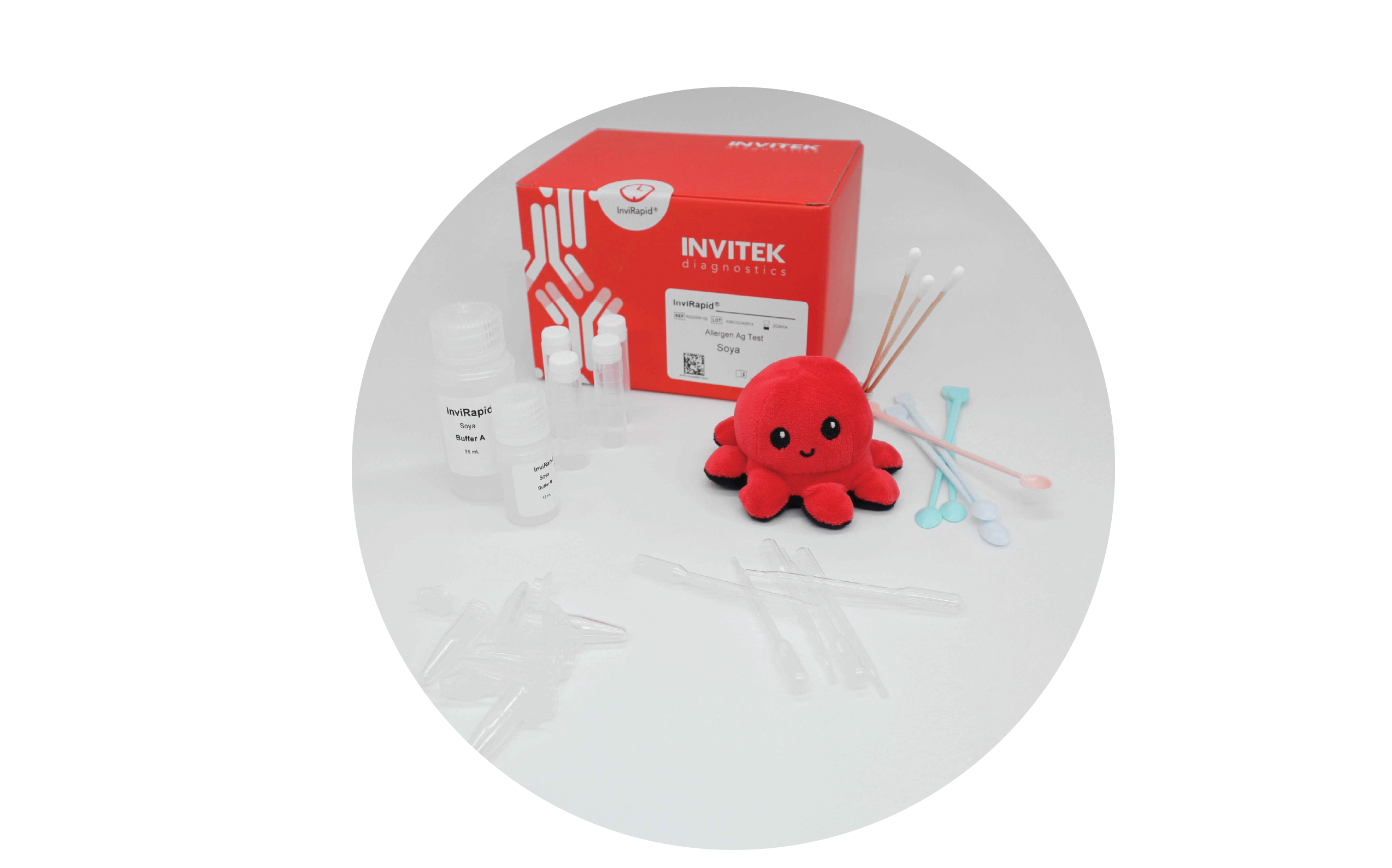 Red Invitek Diagnostics InviRapid Soya Allergen Ag Test box behind buffer bottles, sample tubes, and swabs with scoops, droppers and tubes laying scattered in front.
