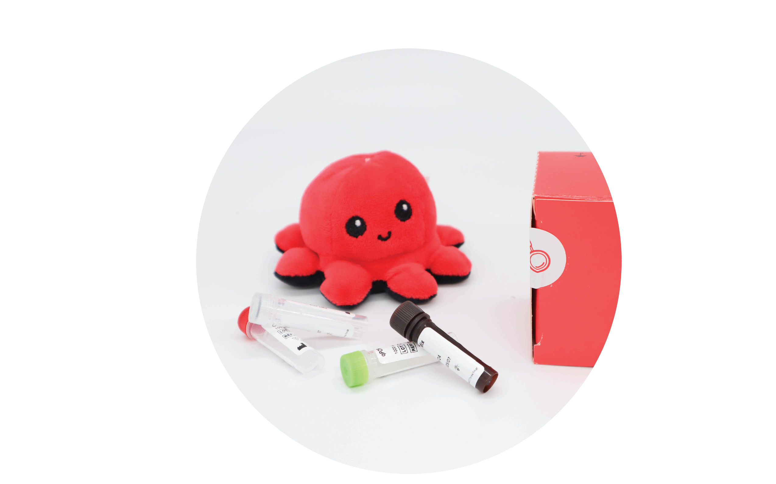 InviScreen SARS-CoV-2 4G kit: plush octopus beside red INVITEK box, with mixed reagent vials (clear, green, brown caps) lying in foreground.