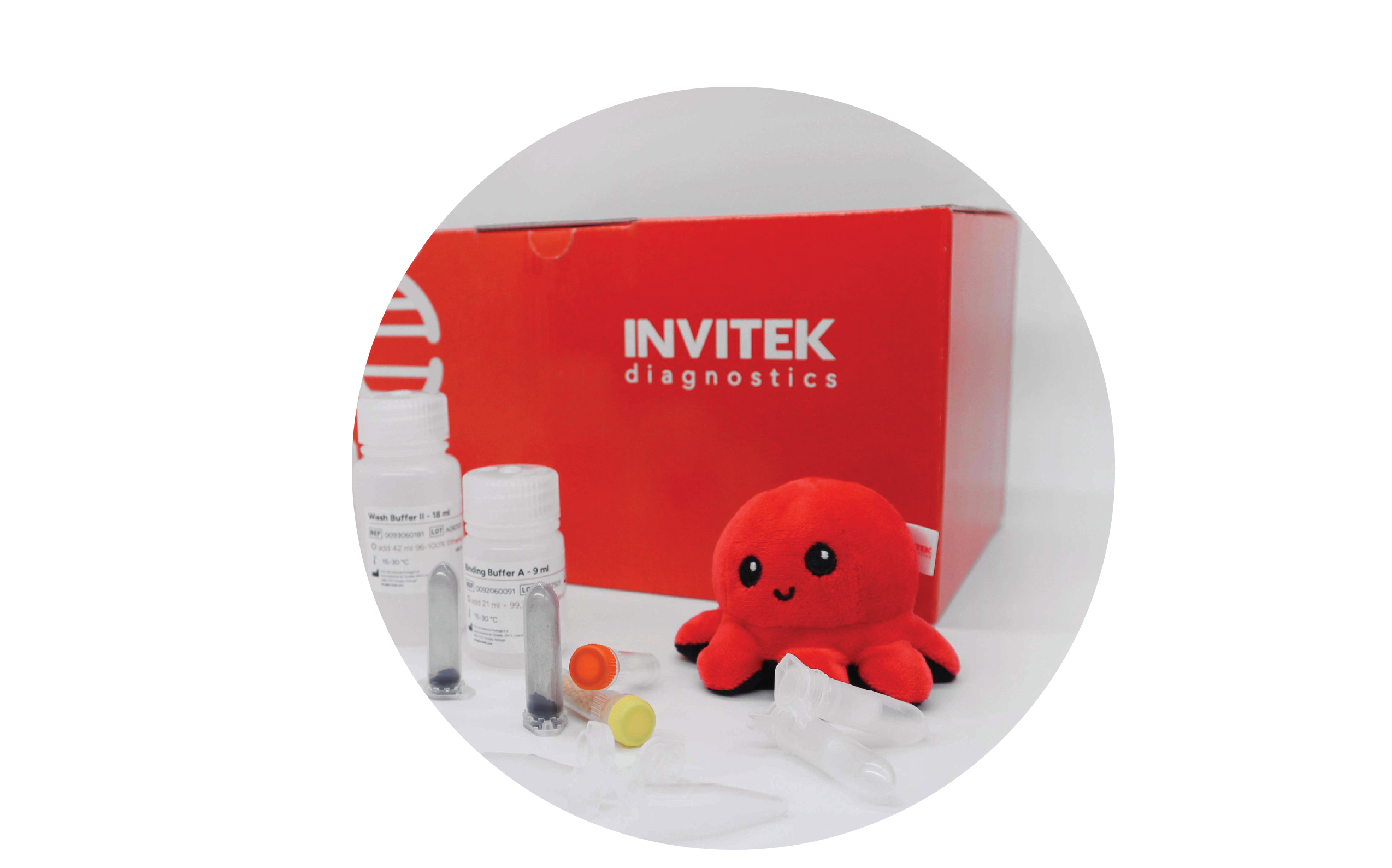 Red Invitek Diagnostics PSP Spin Stool DNA Basic Kit box behind reagent bottles, color-coded reagent vials, and tubes laying scattered in front.