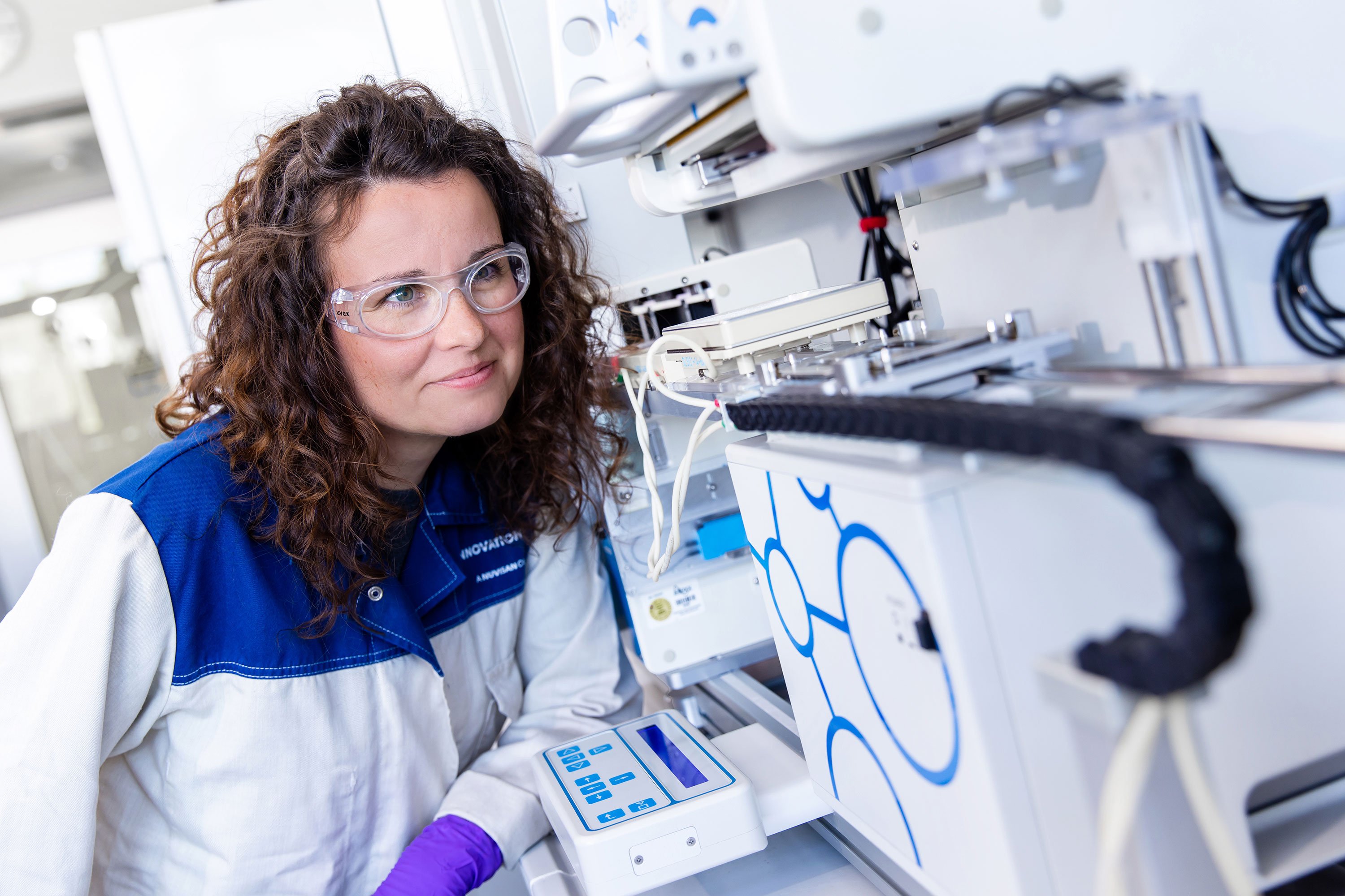 Scientist in a labcoat inspecting an HTS robot