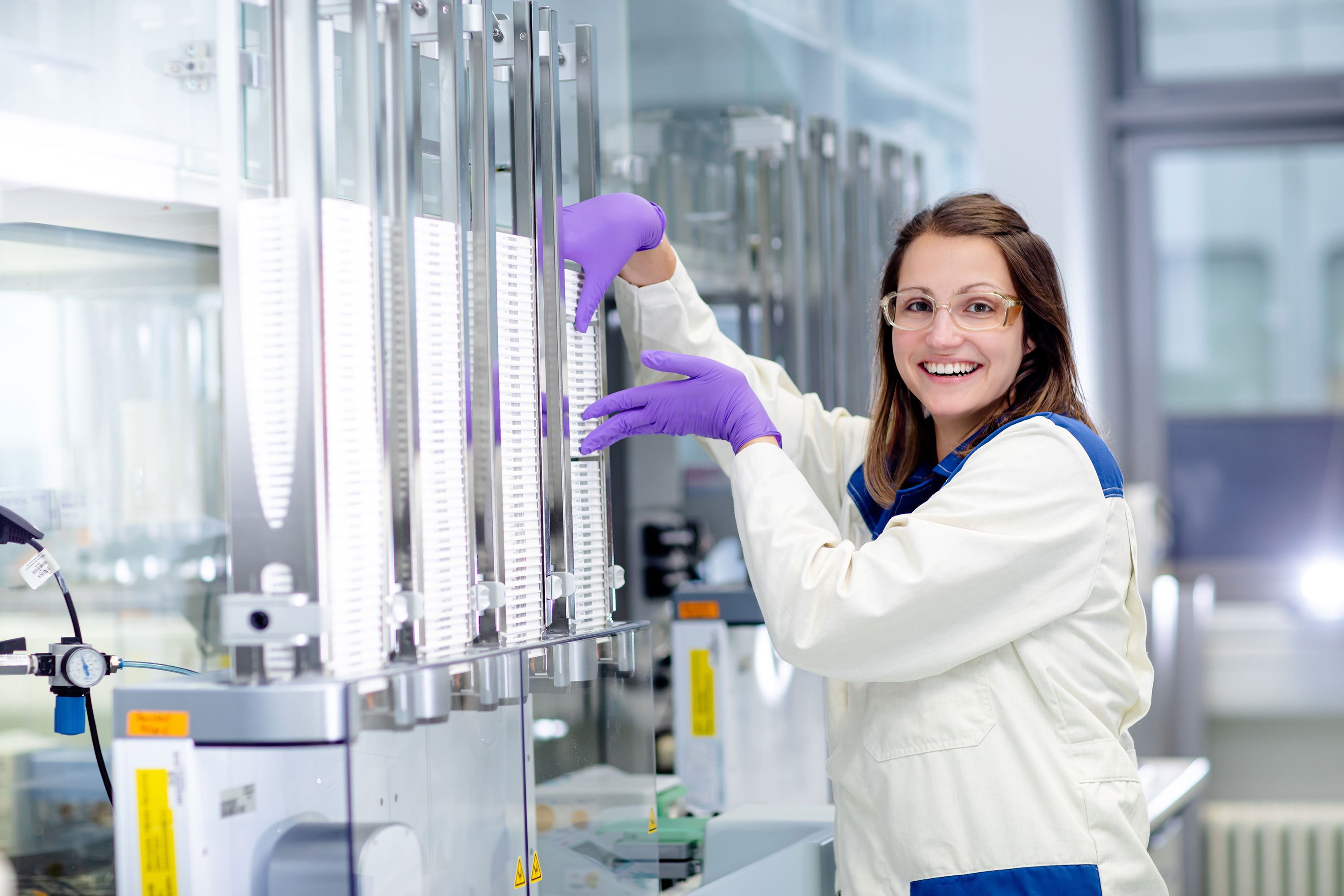 Screening expert processing a stack of assay plates 