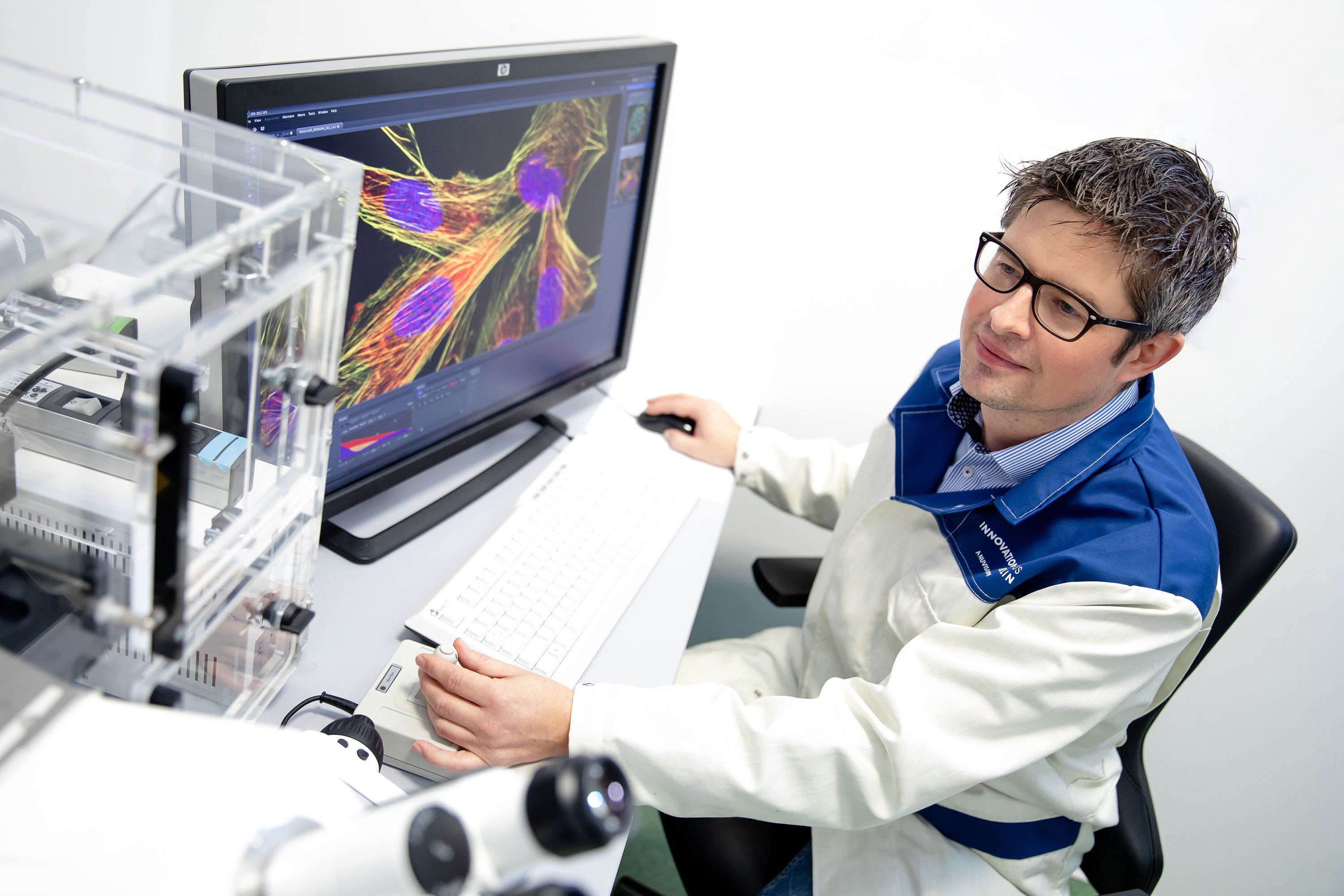 Scientist using a computer for immunofluorescence microscopy in a lab