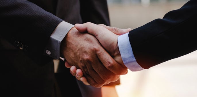 Close up of business man in suit shaking hands