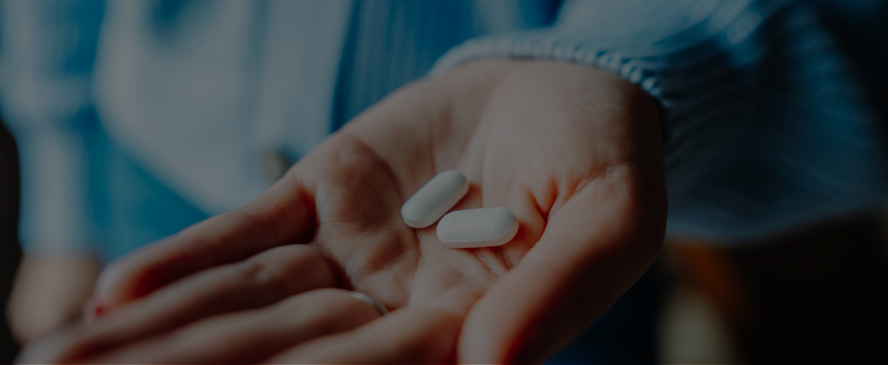 Nahaufnahme der Handfläche einer Frau mit zwei Tabletten