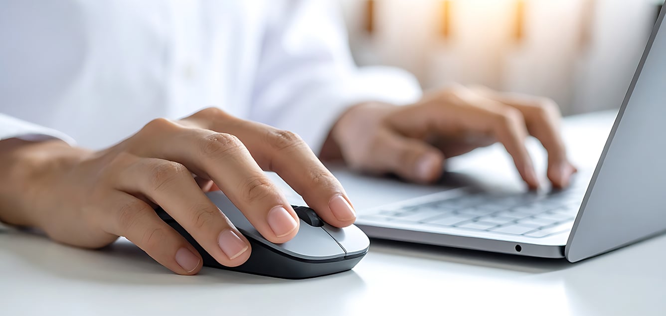 Bedienung von Laptop und Maus durch eine Person