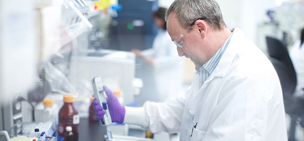 Man wearing a white lab coate working in laboratory