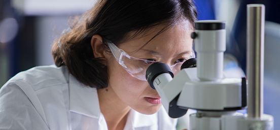 female scientist using a microscope in a lab