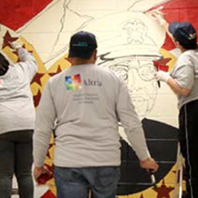 three employees painting a wall