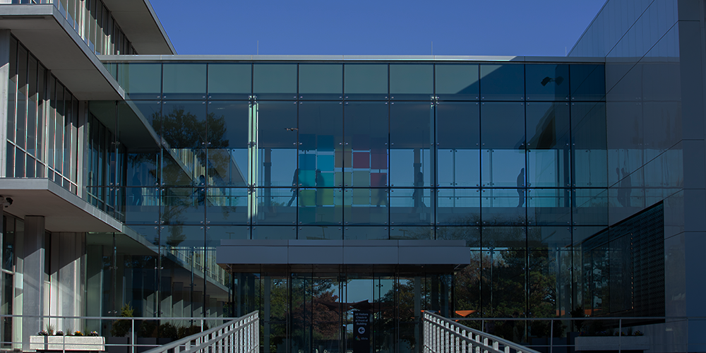 side entrance of altria headquarters building with employees walking through an overhead walkway between buildings