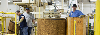 CA Transparency Supply Chain Act image - Three male manufacturing plant workers opening large barrels