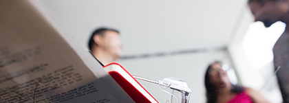 Human Right Framework Image - A red covered book over a thin sheaf of papers on top of a glass table with two people in the background