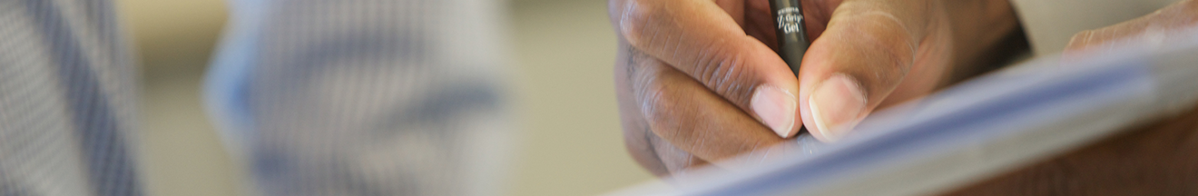 detail of hand signing papers