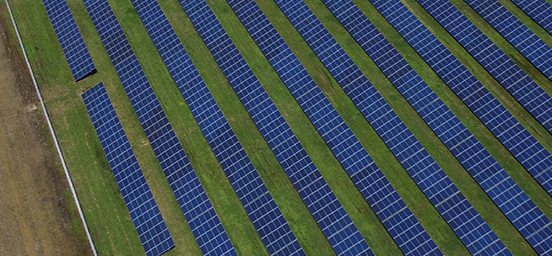 A close-up of a green field covered with solar energy panels