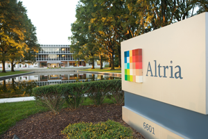 Street view of the front of the Altria headquarters in Richmond with a close-up of the address sign in front and the reflecting pond between the sign and the building
