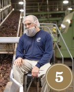 man inspecting tobacco on machine
