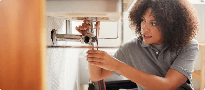Woman fixing leaking sink
