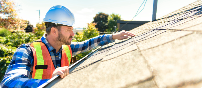 a man inspecting a home's roof