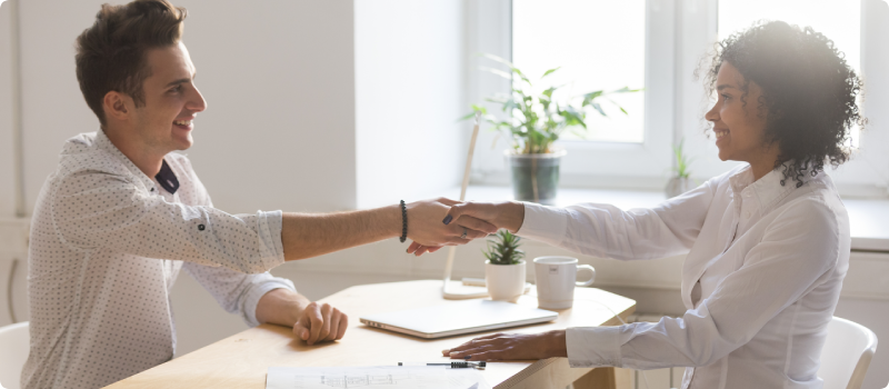 a man and woman shake hands after a negotiation