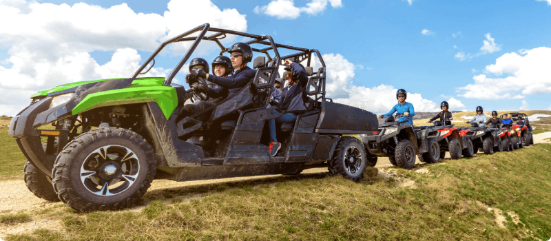 A line of people learning how to ride an ATV. 