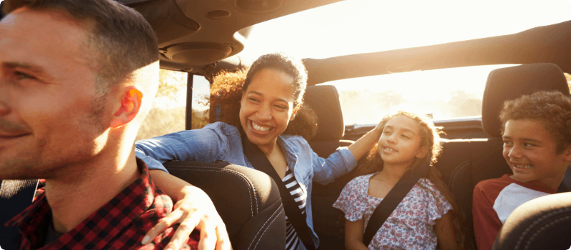 Happy family going for a drive on a sunny day.