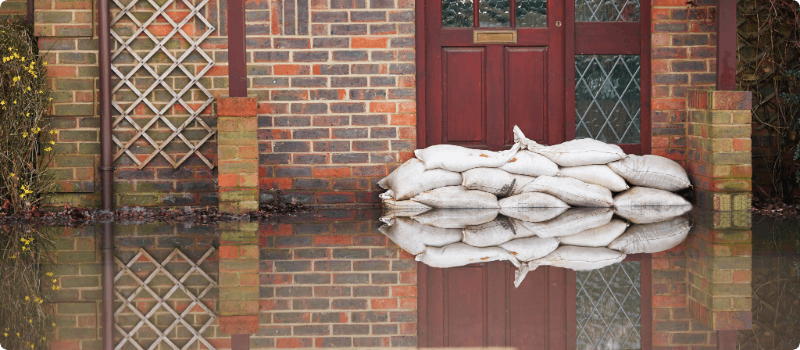 A home with floodwaters rising at its door.
