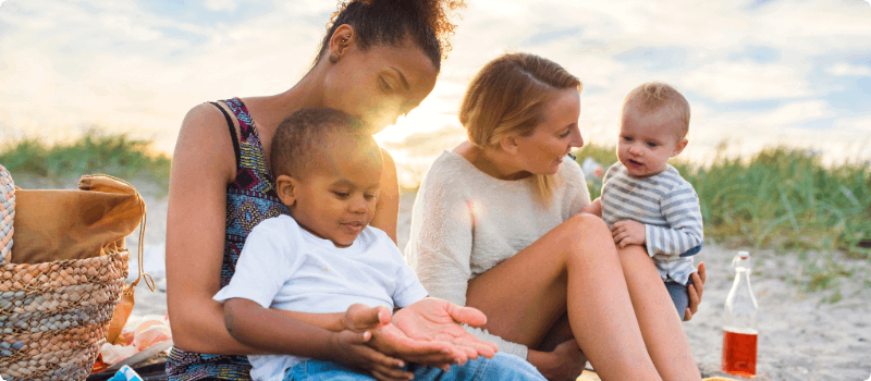 Family sitting on the beach together.