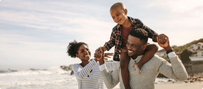 Happy family walking on the beach.