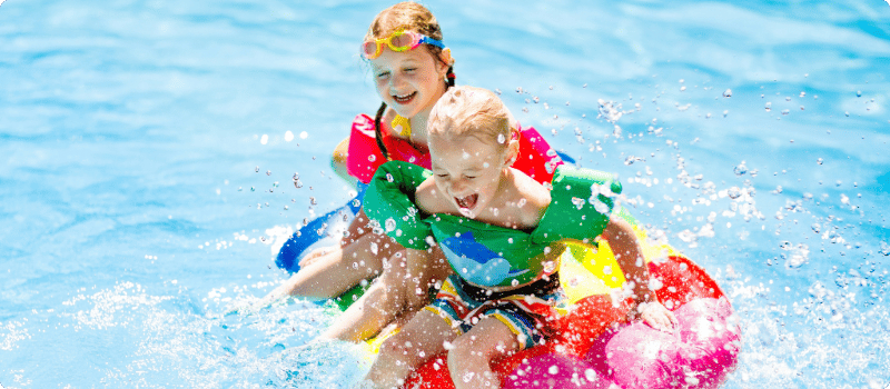 Two kids playing in their pool.