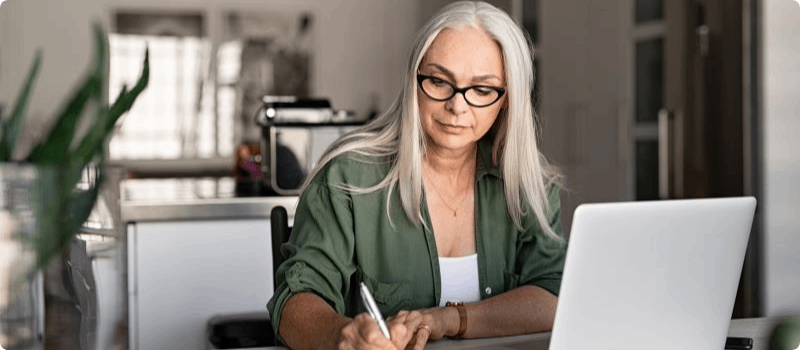 Person working on her laptop at a desk.