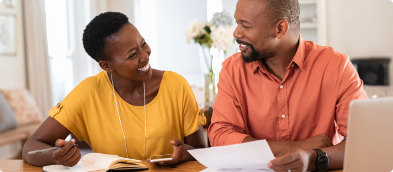 A happy couple working on their bills together.