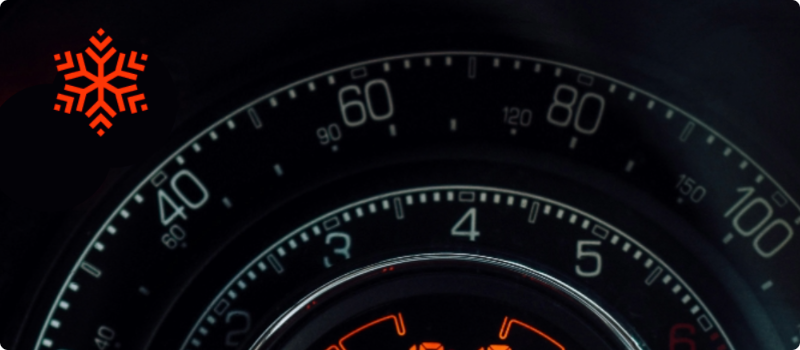 A close-up of a car's dashboard featuring a frost warning light illuminated.