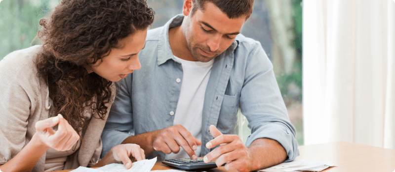 A couple working on their budget together at their desk.
