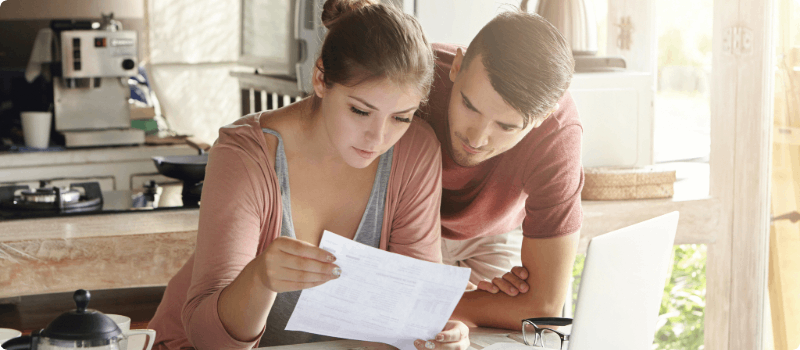 A couple reviewing a bill at a desk.