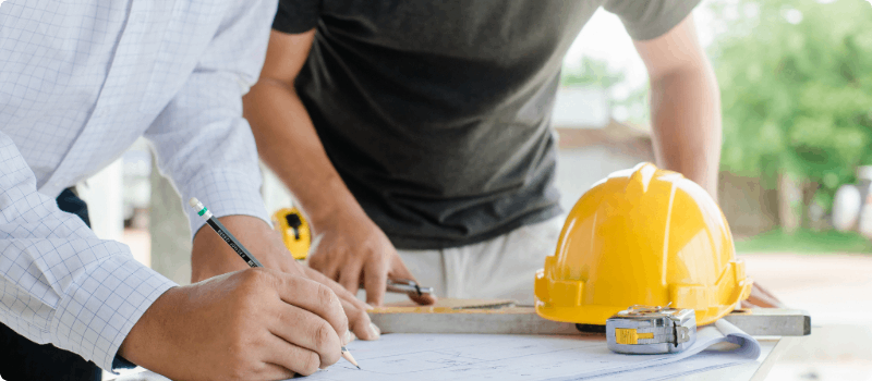 Two contractors reviewing blueprints.