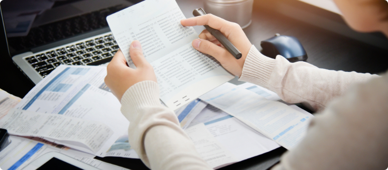A person sitting at their desk, balancing their checkbook. 