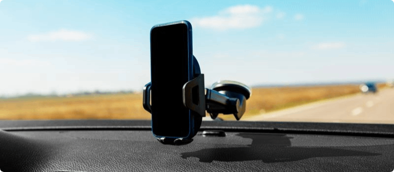 Phone resting in a car mount attached to a windshield.
