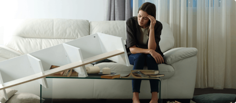 A distressed robbery victim sitting on her living room couch. 