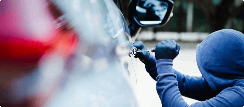 Thief breaking into a car.