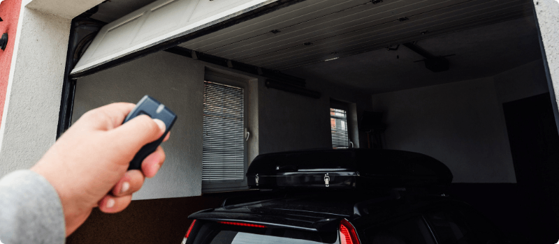 Person closing their garage door with a remote.