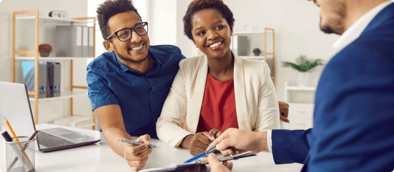 Couple reviewing a contract with a real estate agent.