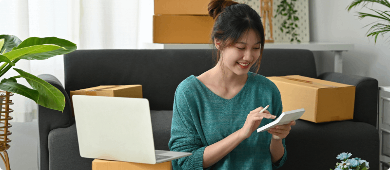 Person holding a calculator in front of a laptop.