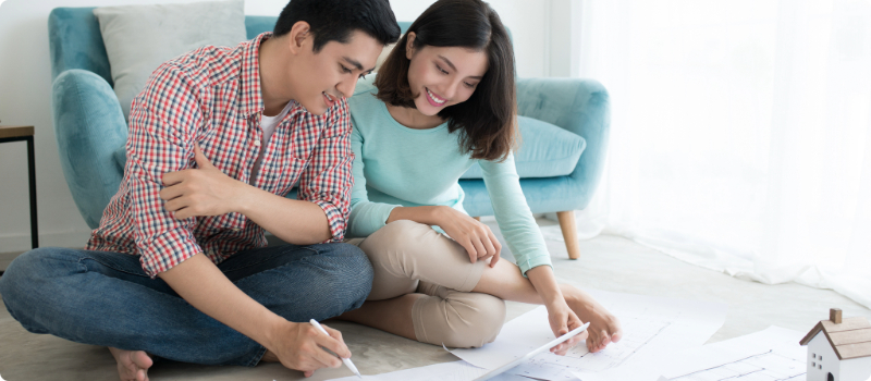 A happy couple reviewing home blueprints.