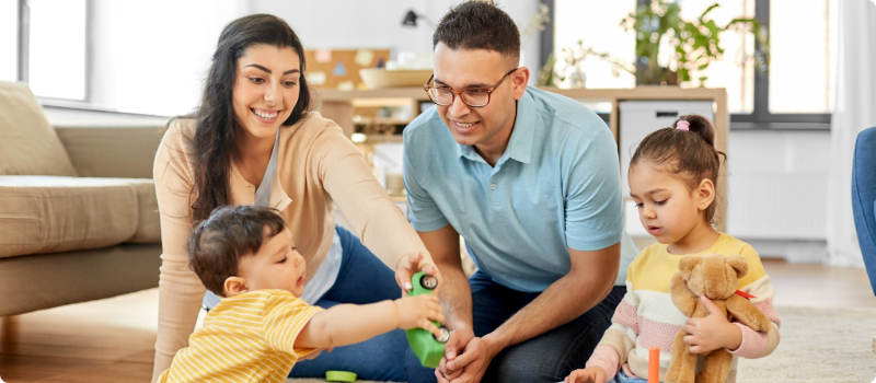 A happy family playing together in their home living room.