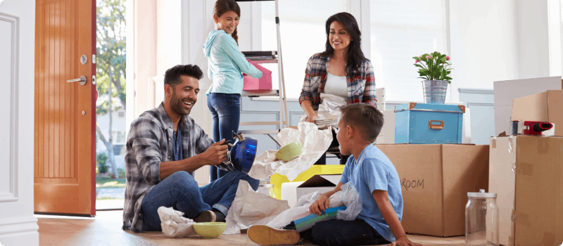 A happy family unpacking their belongings in their new home.