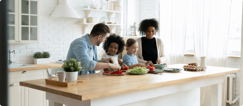 A happy family cooking in their kitchen together.