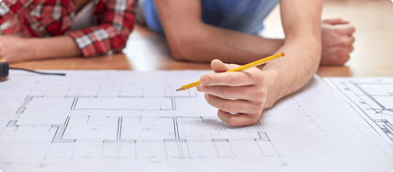 Two people looking at home blueprints.